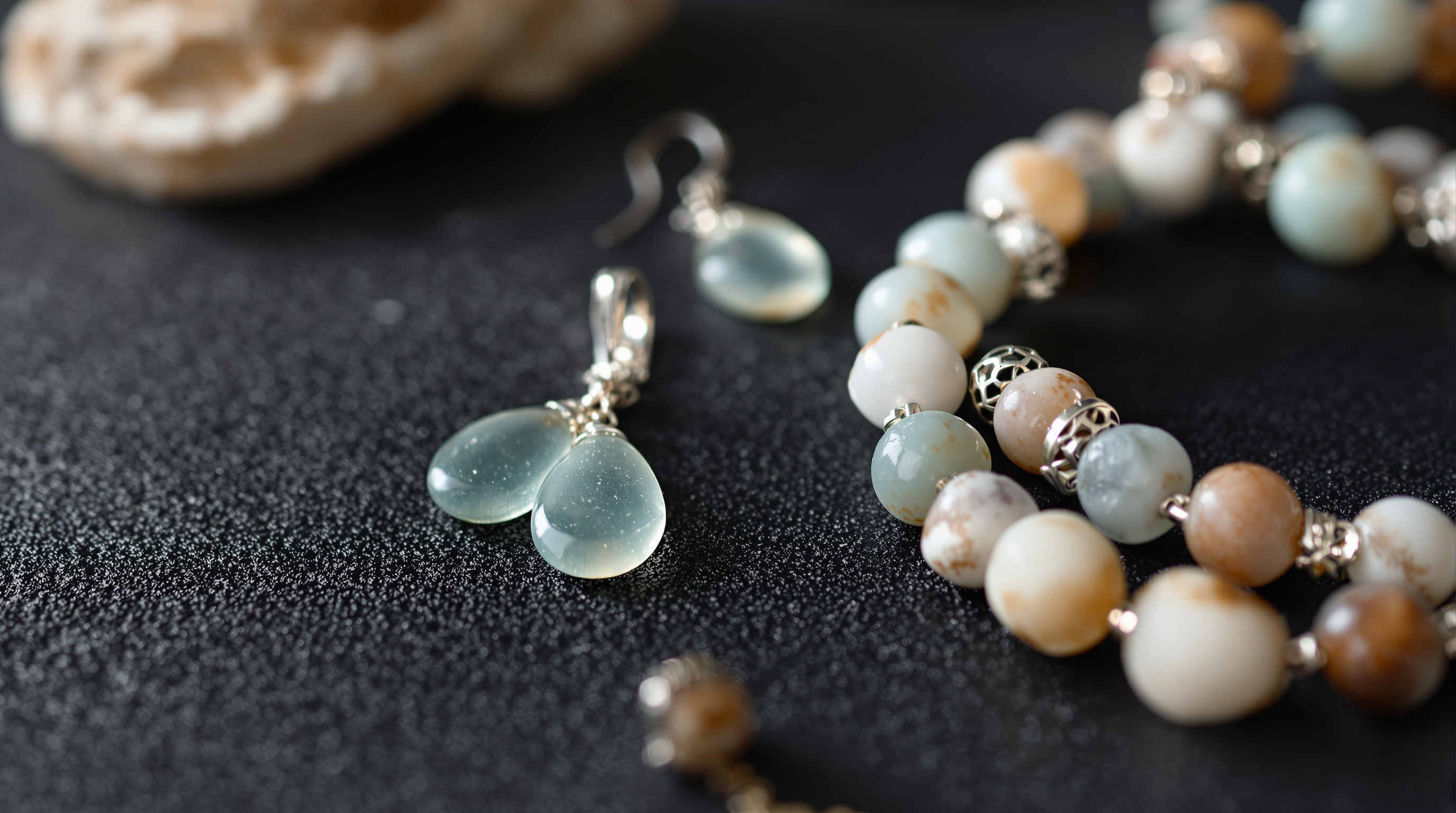 Handcrafted silver and stone jewelry displayed on dark linen